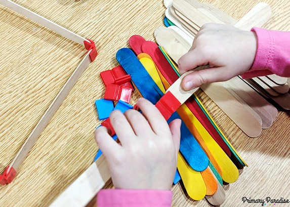 Image of student using popsicle stick connectors to build a STEM project