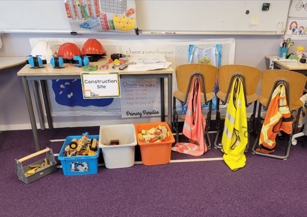 a construction center with building tools, high res vests, hard hats, building plans, and building toys like legos and blocks