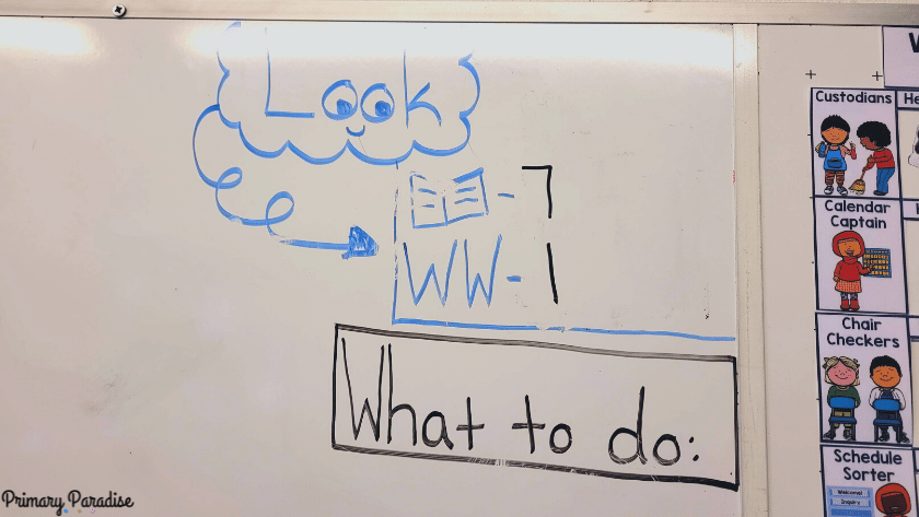 Look written on a white board. Underneath there is a picture of a book with the number 7 and the letters WW for welcome work with the number 1.