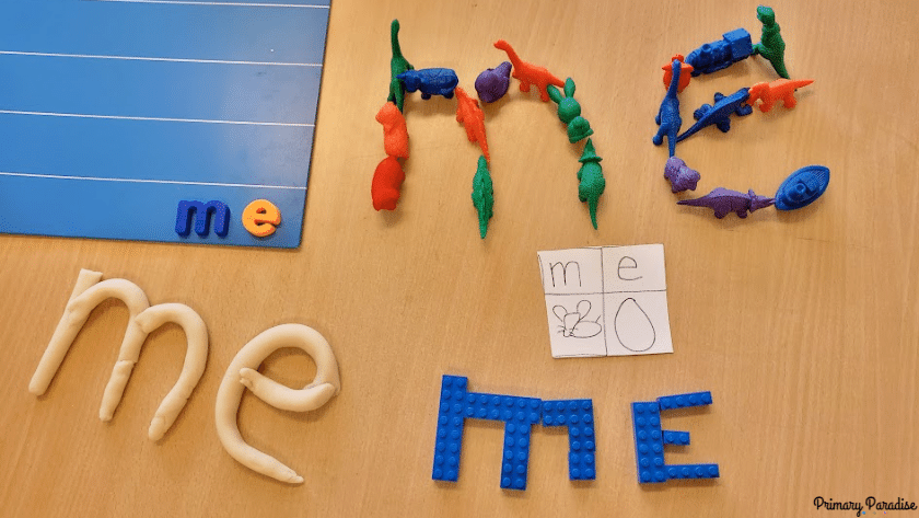 An image of the word me made with magnets, dinosaur manipulatives, legos, and playdoh