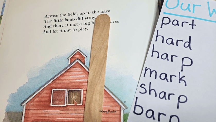A page of a story book with a popsicle stick pointing to the word barn in the text. On the right there is a list of /ar/ words, one of which is barn.