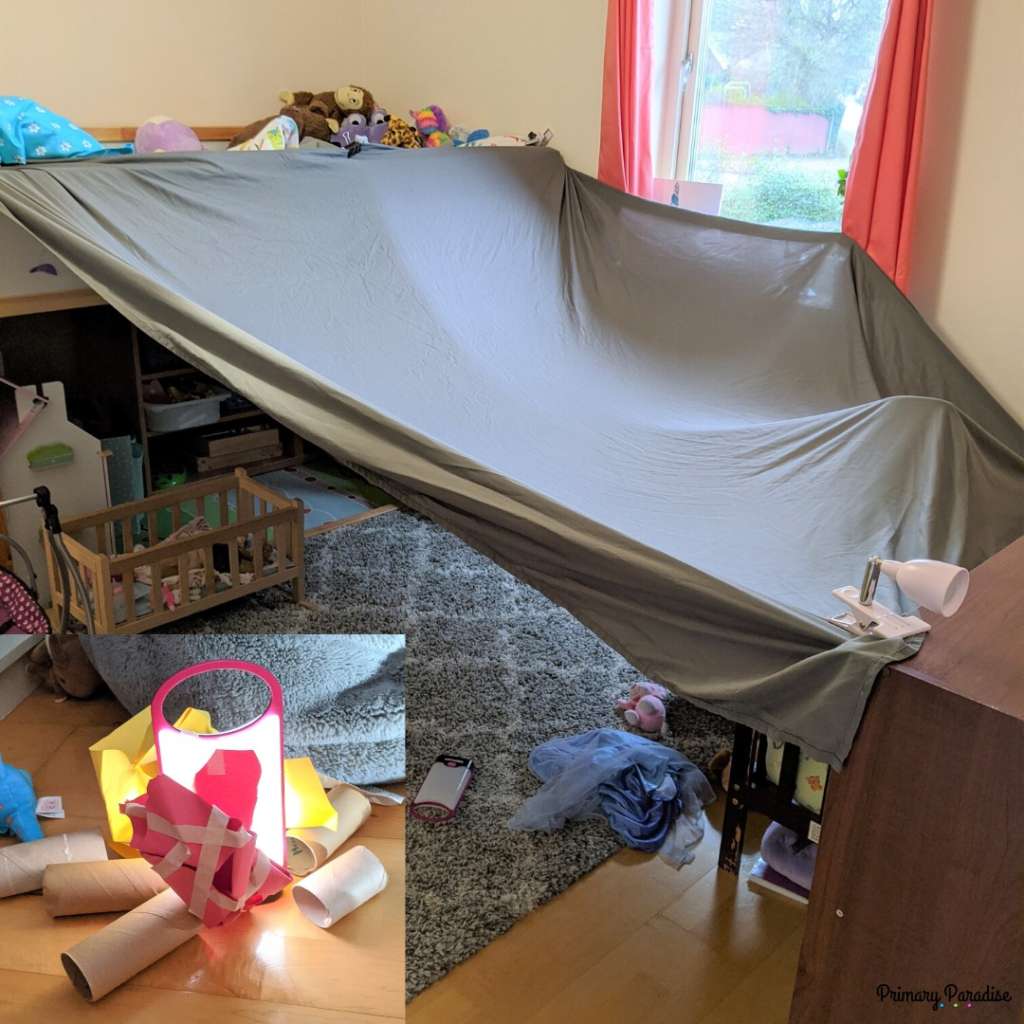 sheet attached to bunkbed and shelf to make a tent: inlay picture- fake campfire made with toilet paper rolls, flashlight, and construction paper