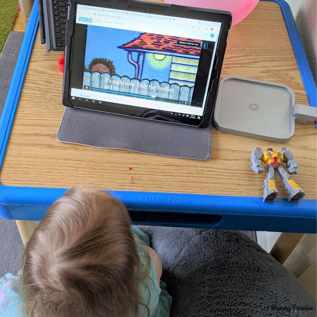 little girl watching tablet with animated story book
