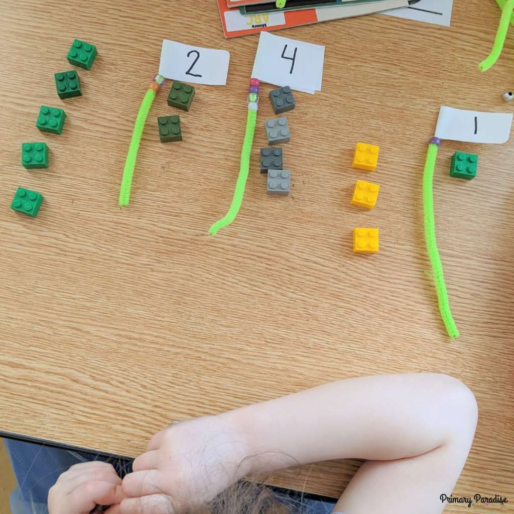 Pipe cleaners with numbers on them and the same amount of legos next to them